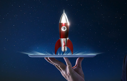 Waiter hand holding an empty digital tablet with Metallic red antique style rocket space ship , Startup creative concept .