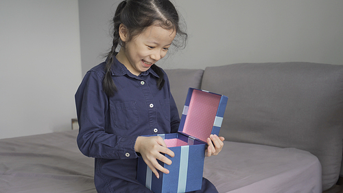 Asian little girl very happy and excited when receives a gift box, New year, Merry Christmas or Birthday present gift concept
