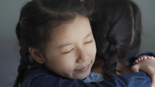 Beautiful and adopted asian little girl hugging, sweet moment with love