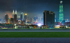 Side view asphalt road with walkway and green grass on night , Kuala Lumpur city .