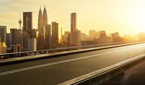 Empty asphalt flyover  road with modern cityscape skyline , sunrise scene .