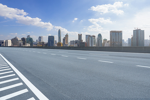 Empty perspective asphalt road with city background, daytime scene.