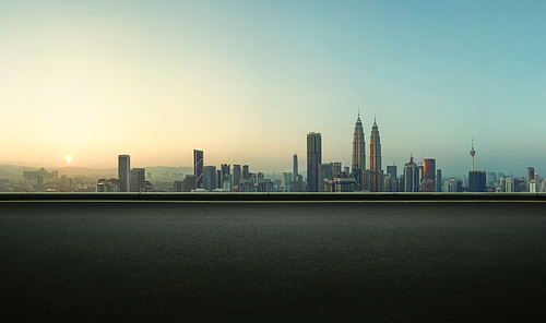 Asphalt empty road side with  Kuala Lumpur city skyline background . Sunrise scene .