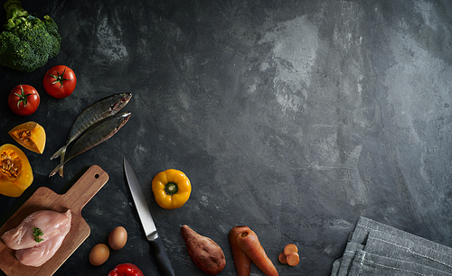 Various healthy raw food and ingredients ready for cooking on cement background . Delicious and tasty food cooking concept . Top view .