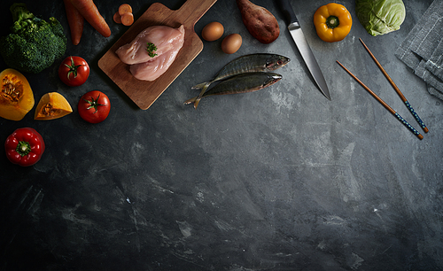 Various healthy raw food and ingredients ready for cooking on cement background . Delicious and tasty food cooking concept . Top view .