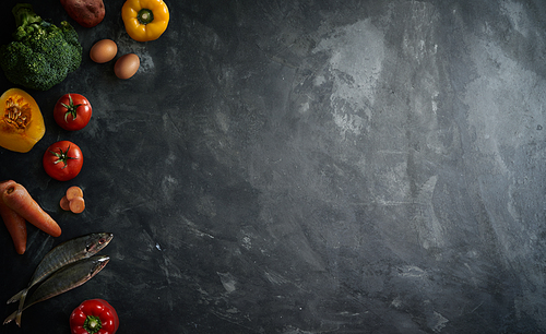 Various healthy raw food and ingredients ready for cooking on cement background . Delicious and tasty food cooking concept . Top view .