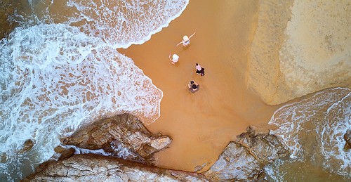 Aerial view of happy family enjoying on tropical beach, summer family vacation travel concept.