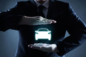 Car (automobile) insurance and collision damage waiver concepts. Businessman with protective gesture and icon of car.