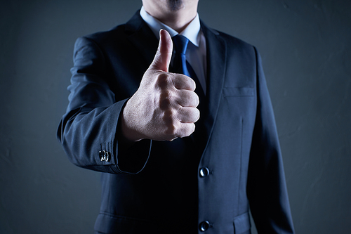 Successful businessman gives thumb up pose. Likes and positive feel. Gesture good and agree , finger agreement