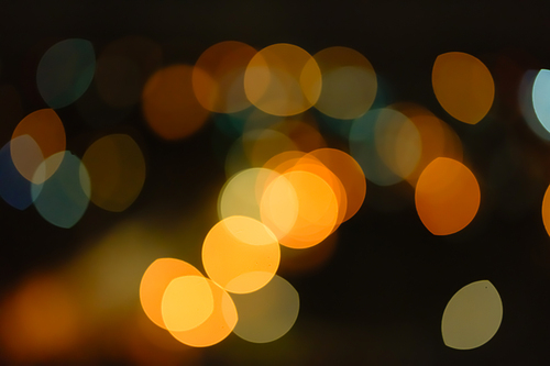 Abstract orange bokeh with dark background.