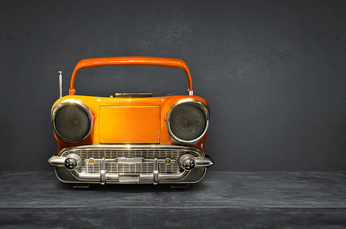 Old antique car shape AM FM stereo cassette player on cement  background