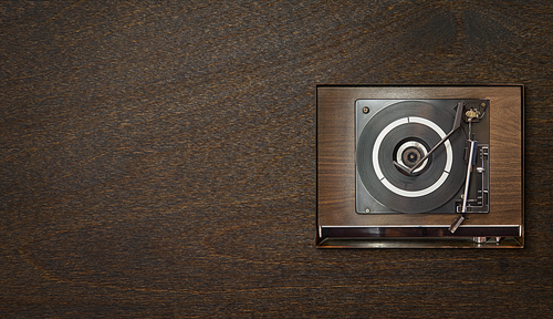 Old vintage retro wooden vinyl record player on wooden background , oldy music entertainment , top view .