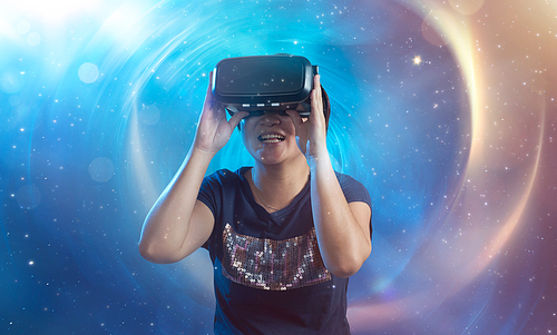 The women wearing virtual reality goggles with amazing cosmic futuristic space virtual imaging background .