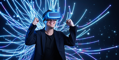 Young man in glasses of virtual reality on futuristic technology background. Augmented virtual reality technology concept.