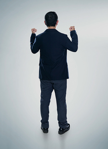 Back view of excited businessman  with arms up