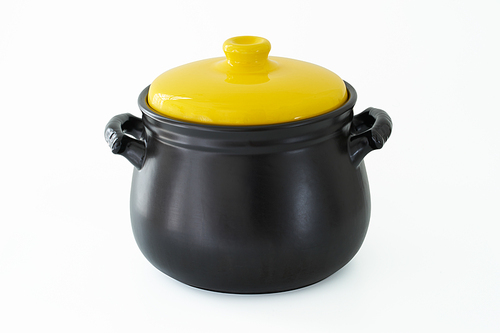 Yellow cap and black cooking pot isolated over white background .