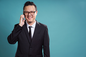 Portrait of asian businessman smile and using smartphone on vintage blue background .