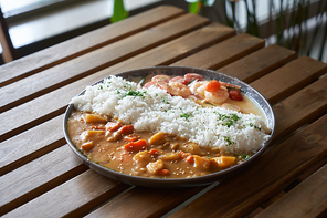 japanese curry 밥 with shrimp,meat, carrot and potato on wooden table