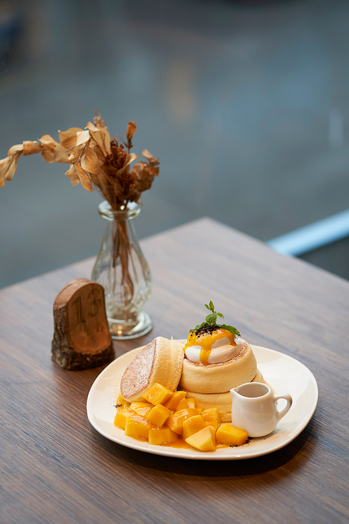 Mango cream cheese cake on wooden table with dry flower and wood craft decor display