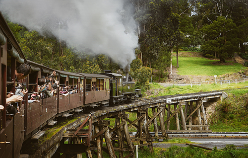 Vintage steam train crossing a wood bridge