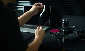 Photographer working checking film negative  ,Stylish home studio concept of hipster . Seleted focus.