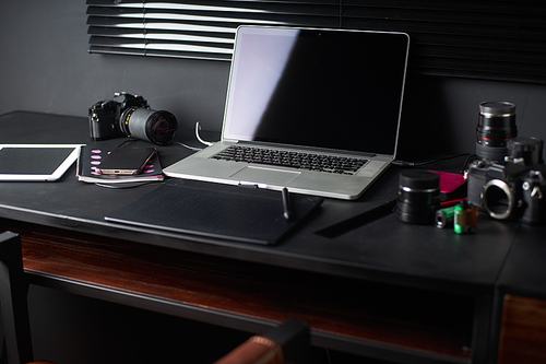 Work space on black table of a photographer or designer with laptop , retro camera , Stylish home studio concept of hipster . Seleted focus.