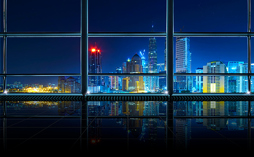 Modern empty and clean office interior with glass windows , Kuala Lumpur city skyline background , night scene .