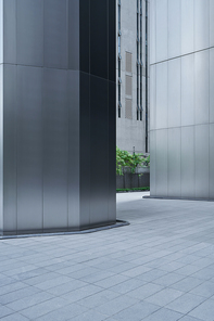 Empty ground in front of modern steel wall buildings .