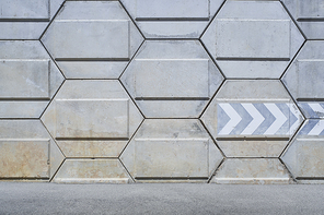 Pentagon shape rough concrete wall with asphalt road background