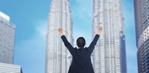 Business success - Celebrating business man overlooking the city center high-rises.