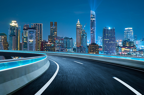 Curvy flyover highway moving forward road with Bangkok cityscape night scene view . motion blur effect apply