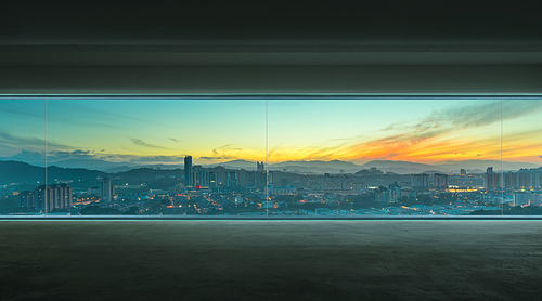 Empty interior with concrete floor and early morning cityscape view .