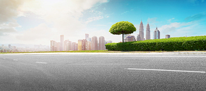 Empty asphalt road with modern city skyline .