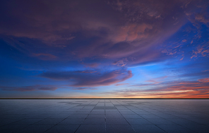 Beautiful vibrant orange cloud and blue sunset sky with empty asphalt floor .