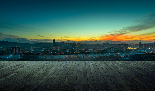 Wooden balcony terrace with early morning silhouette city skyline .