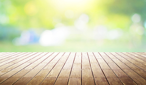 Empty wooden table with out of focus green park background .