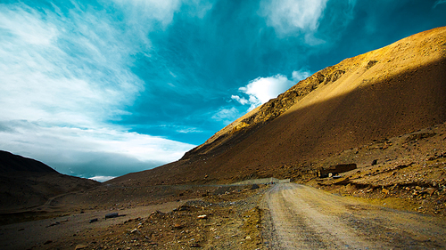 Stunningly beautiful mountain road through the Western Tibet with blue and white clouds sky .