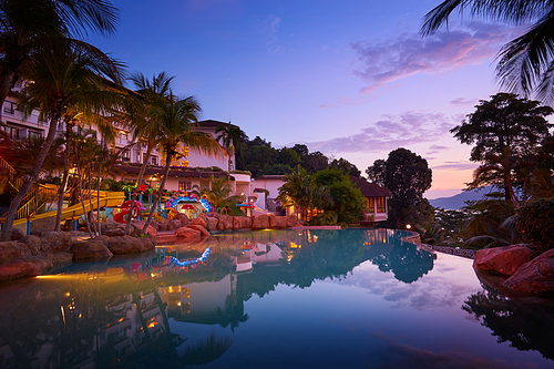 Sunset and romantic atmosphere sky on swimming pool side in Pangkor island . Beautiful travel destination for summer vacation.