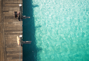Wooden jetty with crystal clear and turquoise sea water of the tropical sea . Aerial top view .Rawa island , Malaysia .