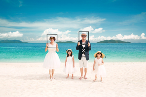 Portrait of happy asian family at sandy beach in summer vacation .