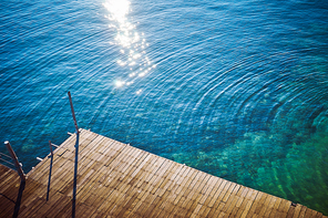 Wooden jetty with crystal clear and turquoise sea water of the tropical sea . Aerial top view .Rawa island , Malaysia .