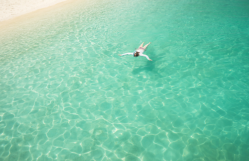 Woman snorkling and relaxing crystal clear and turquoise sea water of the tropical sea .