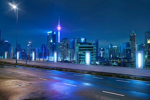Empty side view asphalt with modern city skyline , night scene ,Kuala Lumpur , Malaysia .
