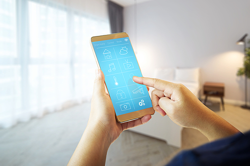 Smart remote home control system apps on a hand phone with blur house  interior background .