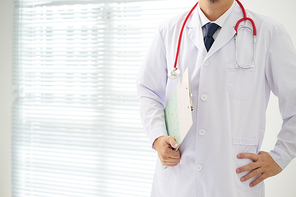 Doctor with a stethoscope and taking notes with bright background .