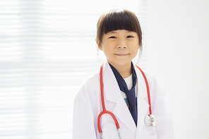 Portrait of little girl dressed as a doctor with a stethoscope  .