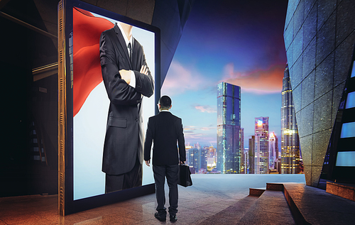 Young businessman looking the hero businessman on the advertising billboard screen . Successful businessman concept .