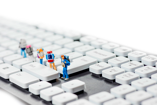 Miniature backpackers on top of the keyboard. Macro photo