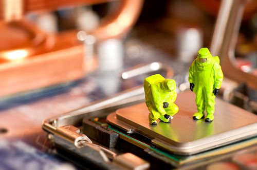 Group of people in protective suit inspecting computer processor