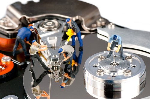 Group of construction workers repairing hard disk drive